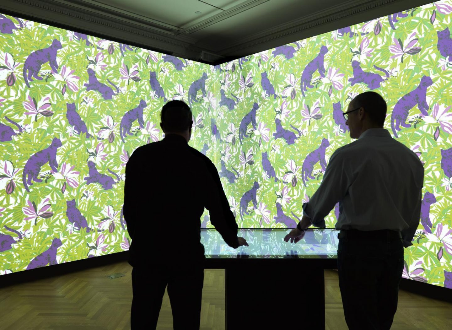 Visitors use an interactive table to project a wallpaper pattern across Cooper Hewitt’s Immersion Room